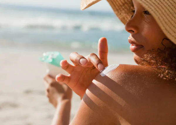 Woman applying sunscreen at the beach