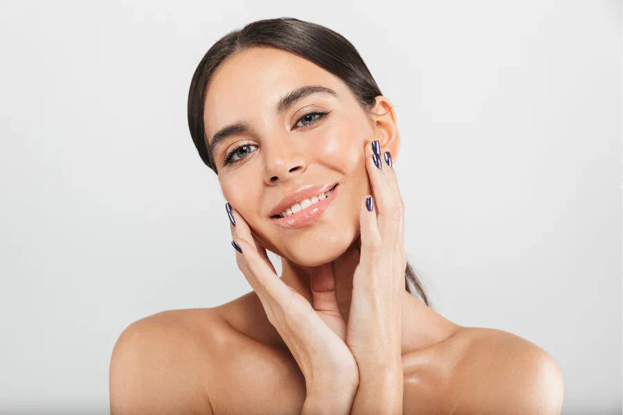 a female with perfect skin touching her face with both hands