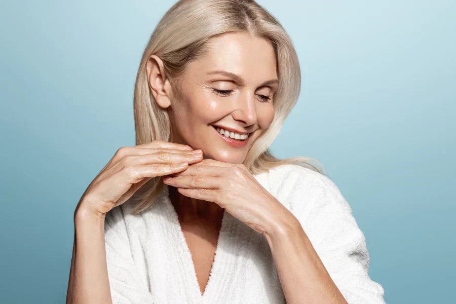 Women with glowy skin smiling & looking down 