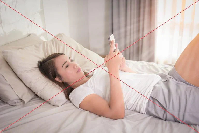 Woman lying on the bed browsing her phone with wrong neck posture