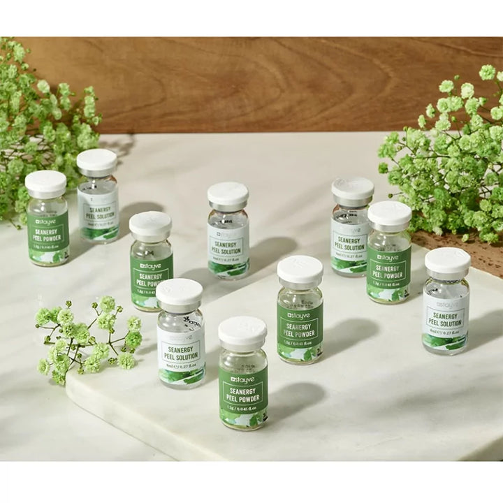 Stayve Seanergy Peel Powder and Solution bottles displayed on marble surface with flowers